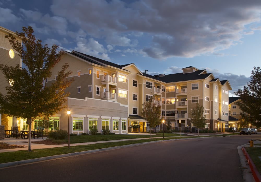A brightly lit apartment complex in the evening.