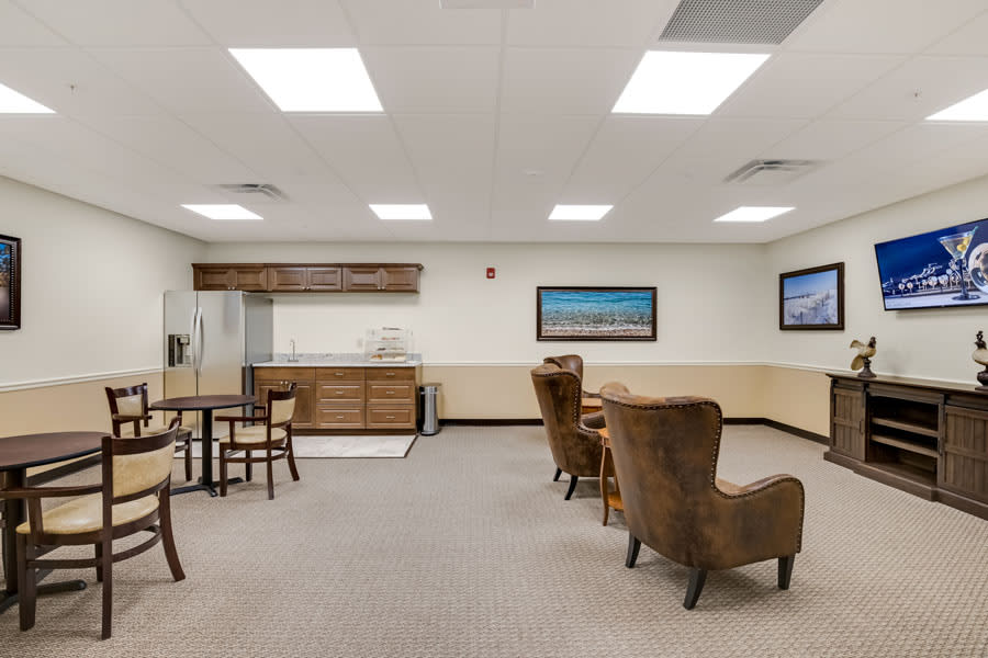 A spacious interior room featuring comfortable seating and tables, ideal for meetings or relaxation.