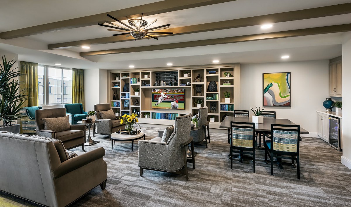 A modern living room with comfortable seating and a large bookshelf.