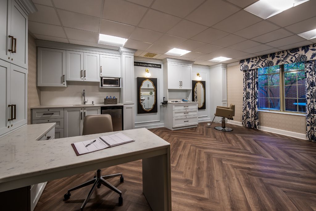 A modern office space with a desk, chairs, and contemporary lighting.
