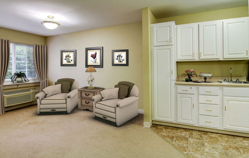 A cozy living room with two armchairs, wall art, and white cabinetry.