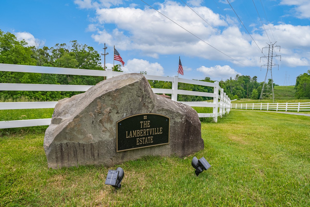 A memorial stone marker with flags in a grassy outdoor setting.