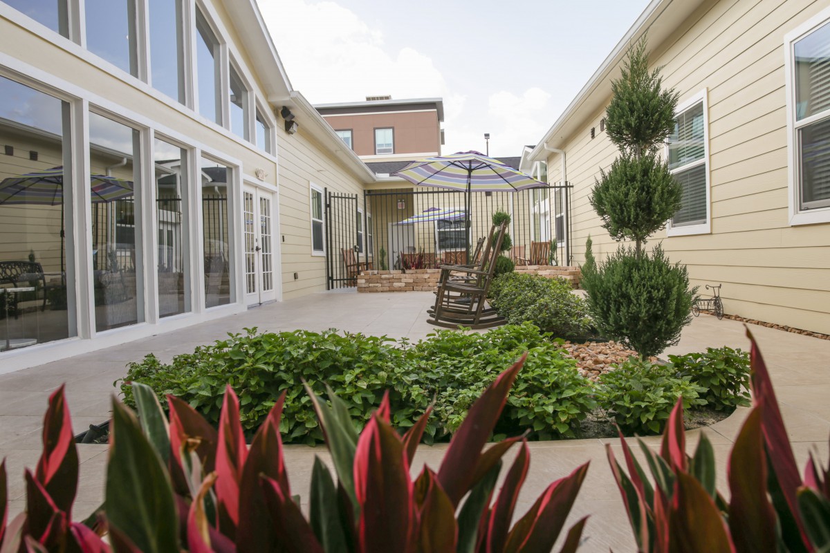 A well-maintained courtyard garden featuring lush greenery and a small patio area.