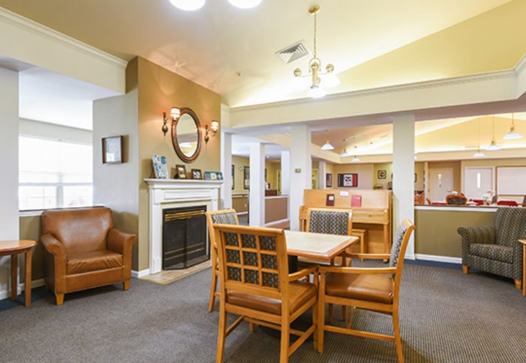 A cozy living area featuring a fireplace, dining table, and comfortable seating.