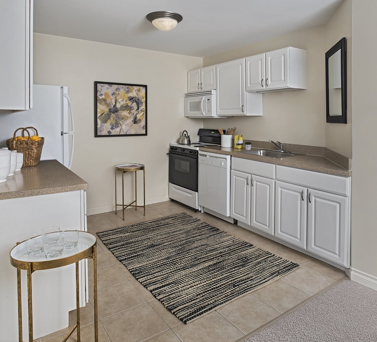 A modern kitchen with white cabinets, appliances, and decorative elements.