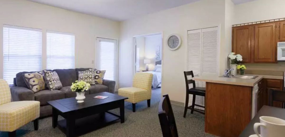 A cozy living room with modern furniture and a small dining area.