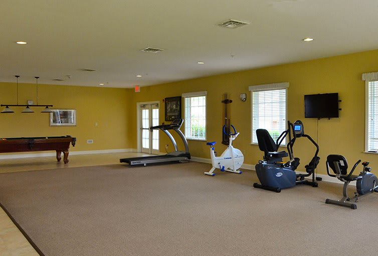 A spacious gym room with various fitness equipment including treadmills and exercise bikes.