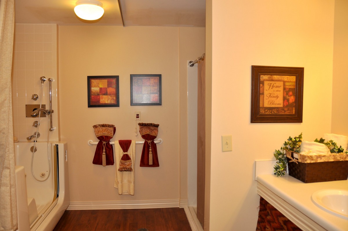 A neatly arranged bathroom featuring decorative towels and framed artwork on the walls.