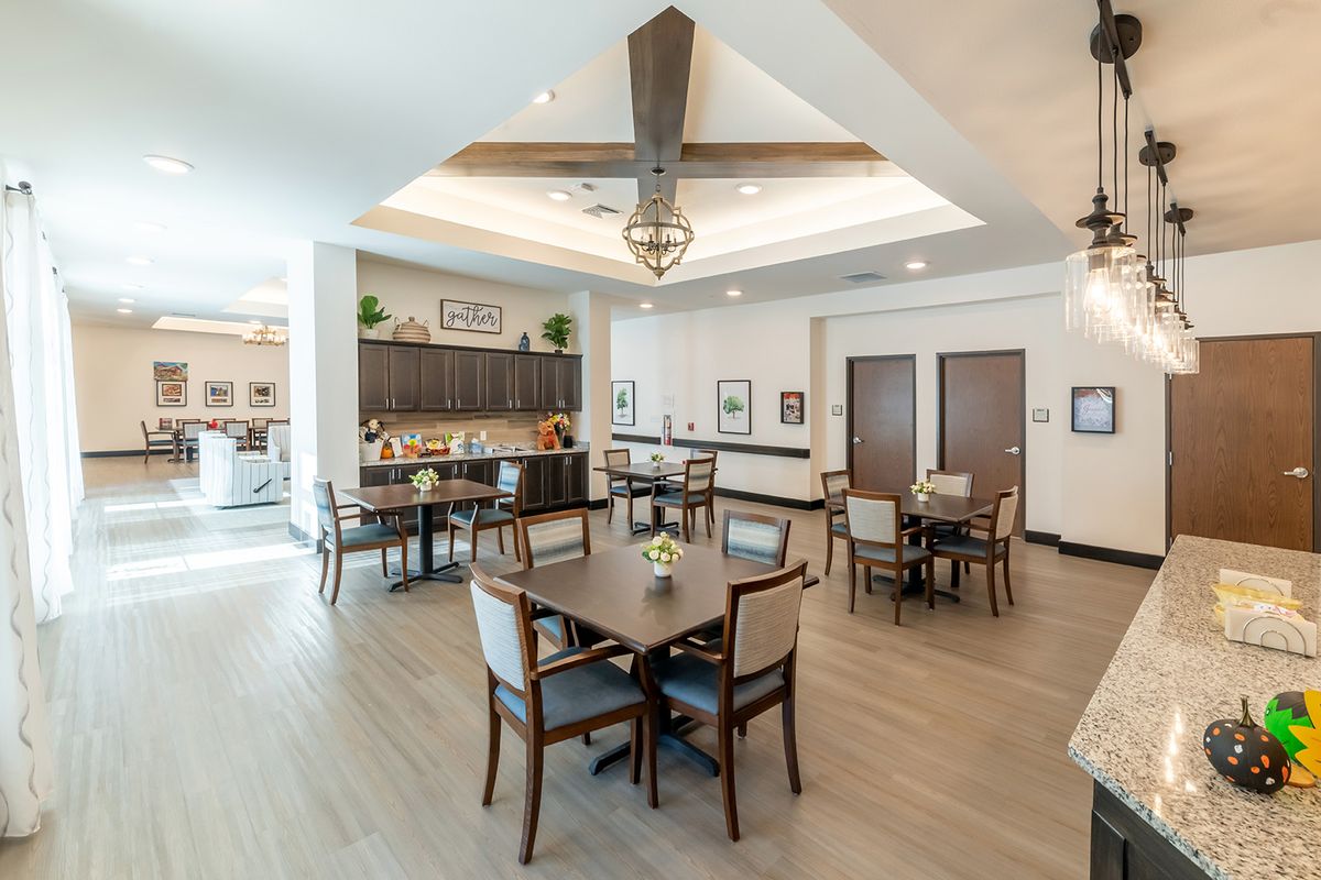 A modern dining area with wooden furniture, bright lighting, and elegant decor.