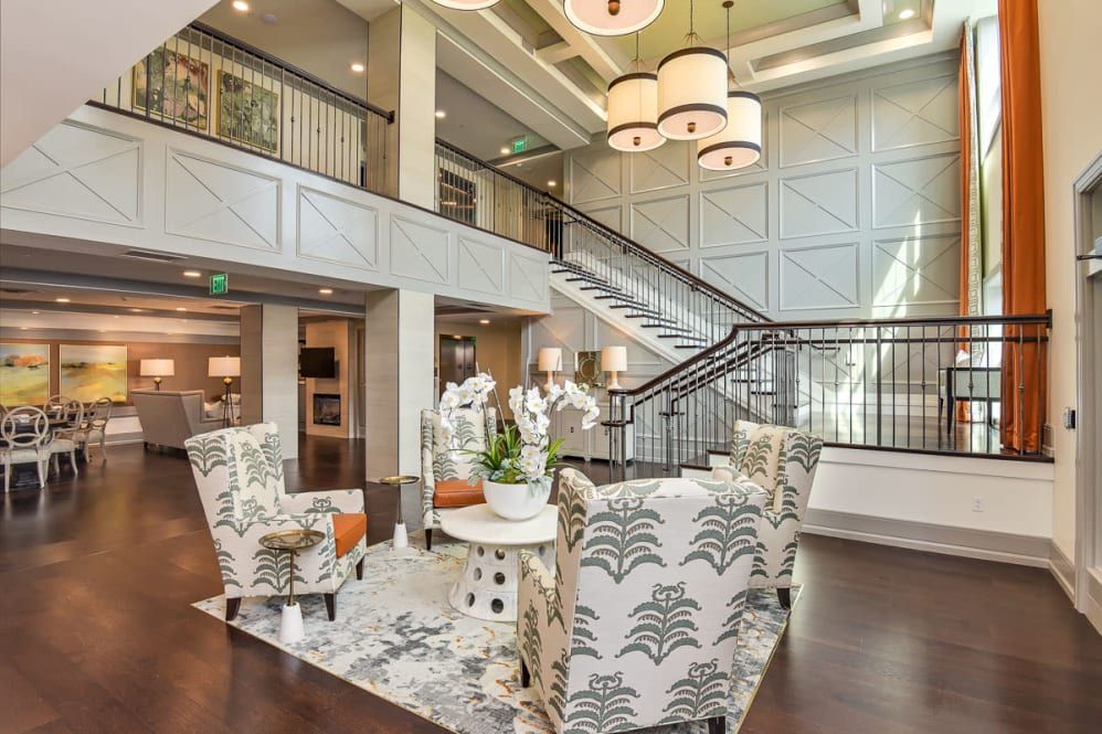 A stylish lobby featuring elegant furniture and a grand staircase.