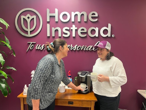 Two employees enjoying a coffee break at the Home Instead office.