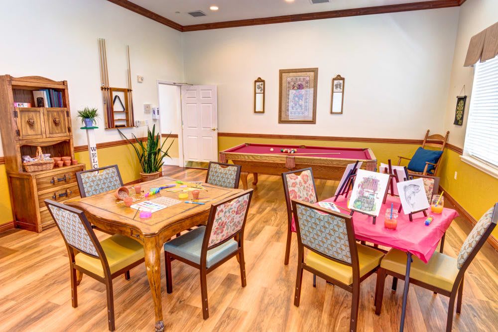 A cozy activity room featuring tables, chairs, and art supplies for creative projects.