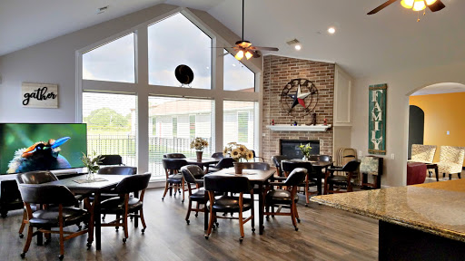 A spacious and inviting lounge area with large windows and a cozy fireplace, perfect for gatherings.