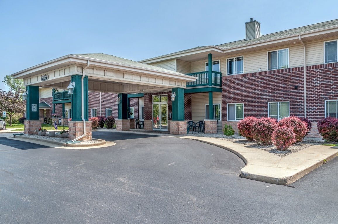 The exterior view of a hotel with a covered entrance and parking area.