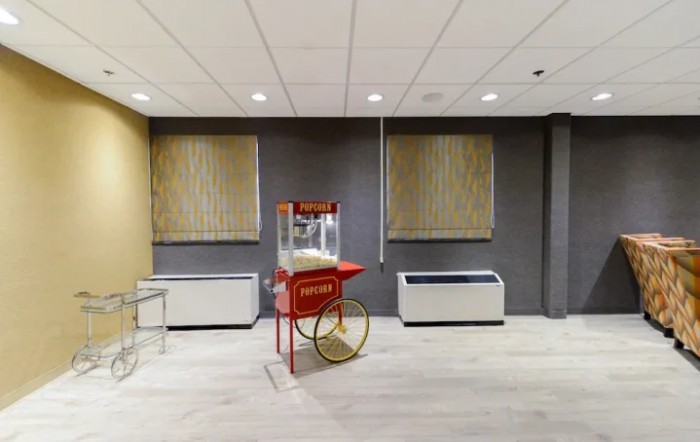 A popcorn machine in a modern indoor setting with neutral-colored walls and flooring.