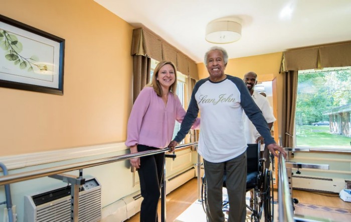 A group of people engaging in a rehabilitation session with the help of walking aids.