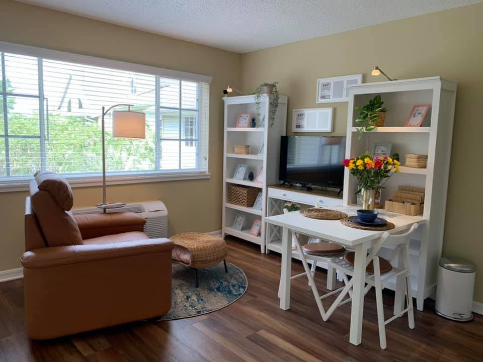Cozy living room with comfortable seating, bookshelves, and a large window.