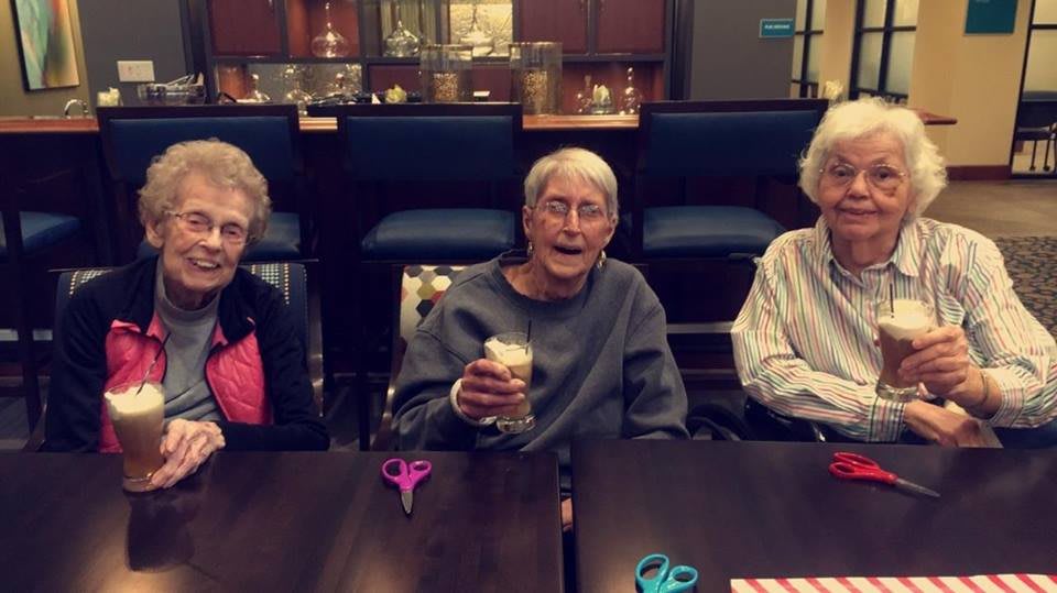 Elderly friends enjoying a social gathering indoors.