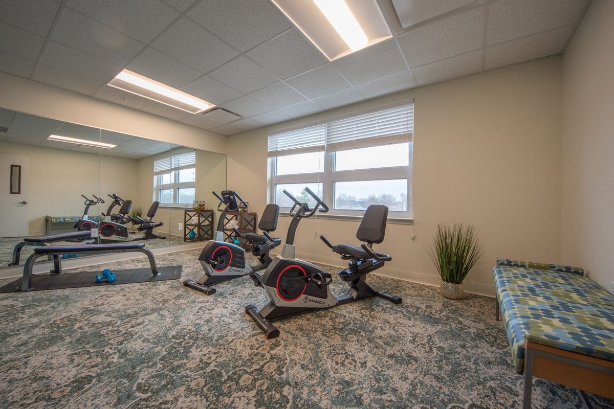 A well-equipped gym room featuring stationary bikes and a modern interior.