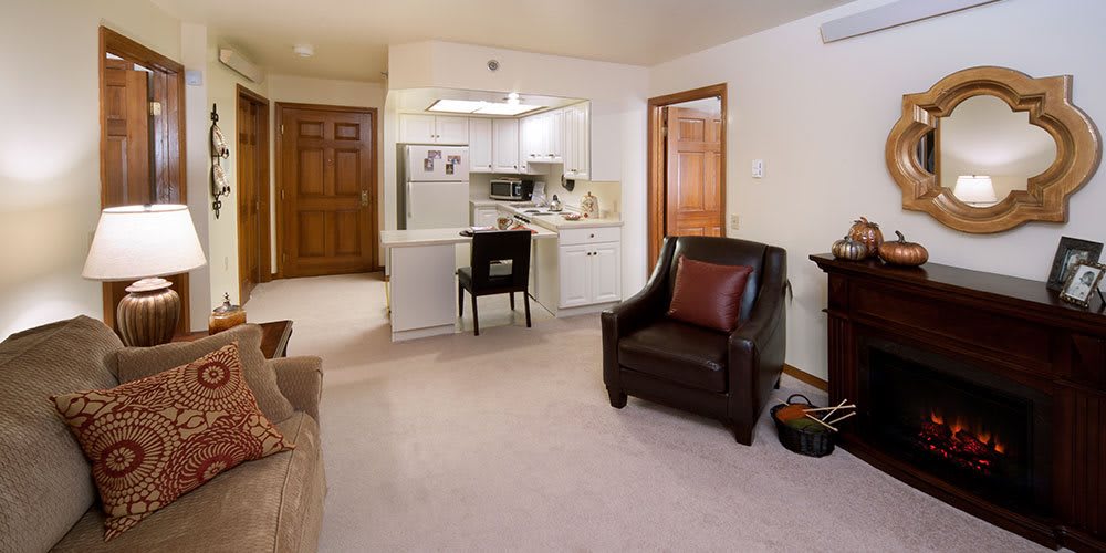 A cozy apartment living area with a view of the kitchen, featuring comfortable seating and modern amenities.