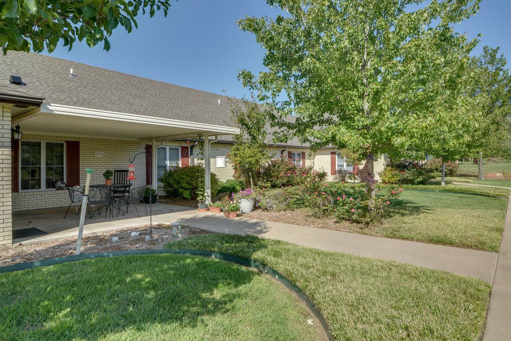 A residential house with a landscaped yard and patio.