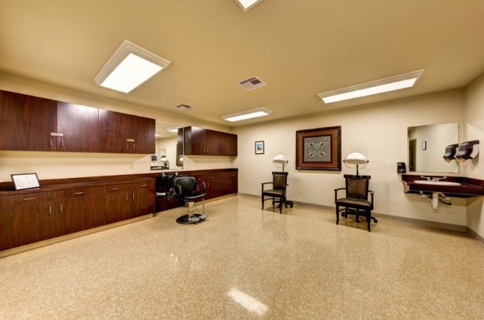 A tidy salon interior with chairs, a mirror, and soft lighting.