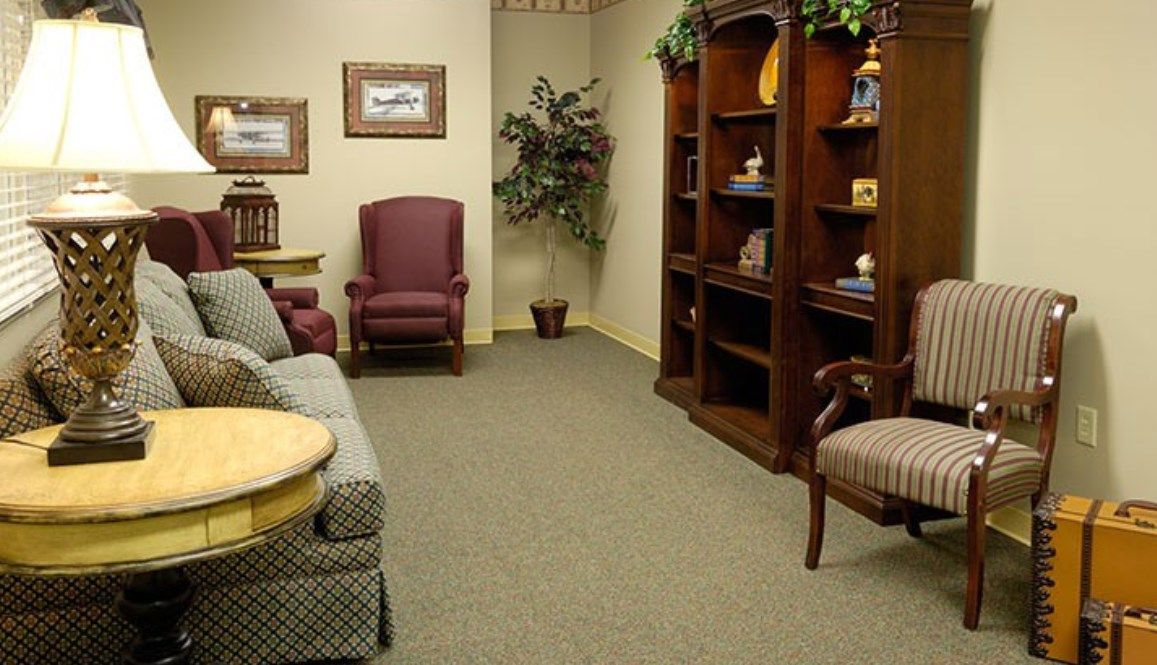 A cozy and inviting waiting room with comfortable seating and a well-organized bookshelf.