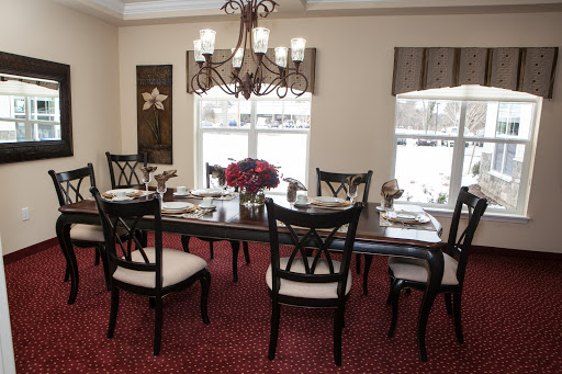A beautifully arranged dining room featuring a wooden table, elegant chairs, and a stunning chandelier.