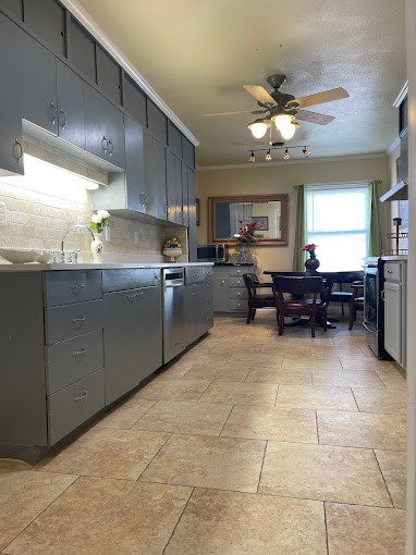 A modern kitchen with sleek cabinets and an adjoining dining area.