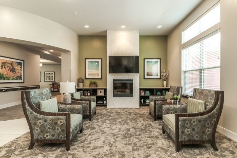 A cozy living room with modern decor featuring a central fireplace and comfortable seating.