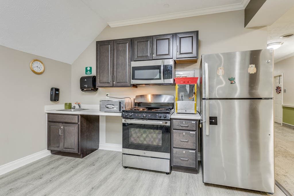 A modern kitchen with stainless steel appliances and dark wood cabinets.