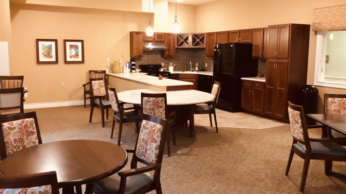 A cozy kitchen and dining area featuring a large island with seating, surrounded by wooden cabinets and modern appliances.