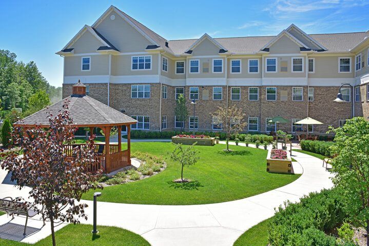 A well-maintained residential building with a central garden featuring a gazebo and pathways.
