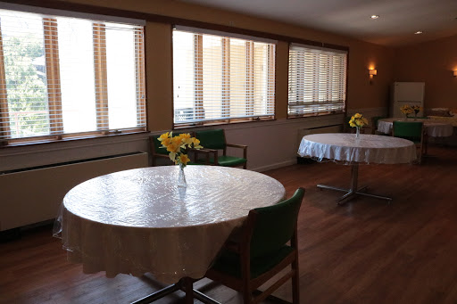 A serene dining space with neatly arranged tables and chairs, illuminated by natural light.