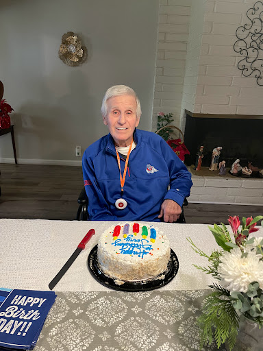 A joyful celebration with a birthday cake and a smiling individual wearing a medal.