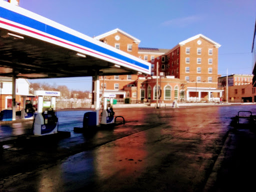 A gas station with an adjacent building under clear blue skies.