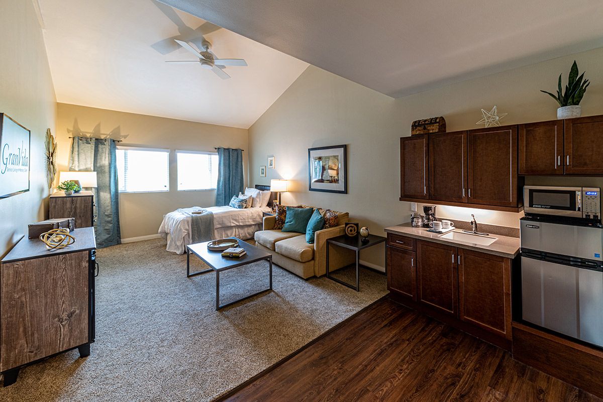 A cozy studio apartment with an open living area, bedroom, and kitchenette.