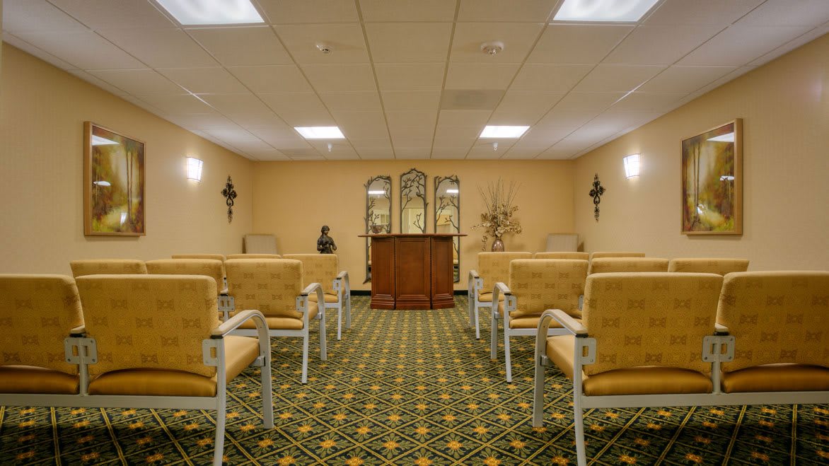 An empty chapel with rows of seating and a pulpit at the front.