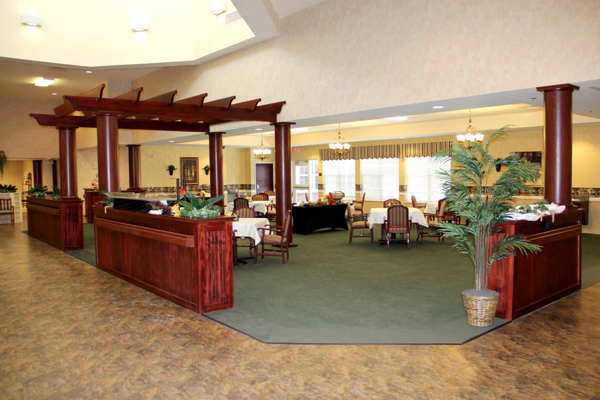 A spacious lobby with a reception desk leading into a dining area.