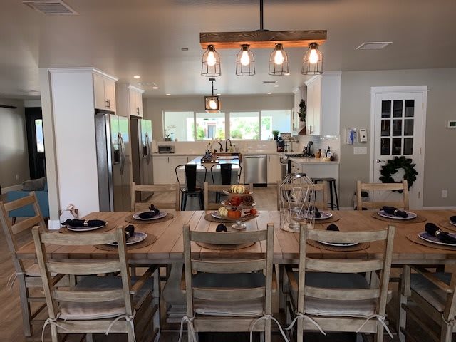A modern open kitchen and dining area featuring a central island and large dining table.