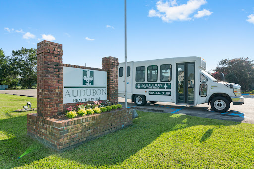 Entrance to the auditorium with a transportation bus parked nearby.