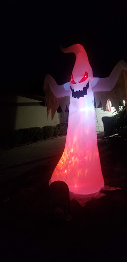 A large, illuminated inflatable ghost decoration for Halloween.