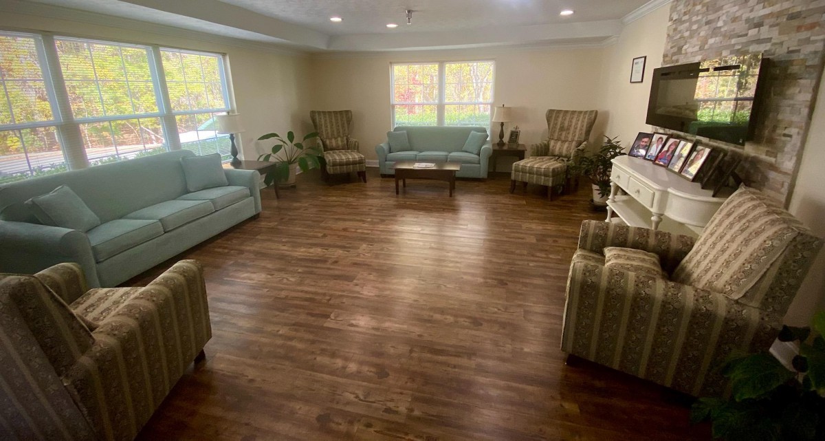 A cozy living room with sofas, chairs, and a wooden floor.