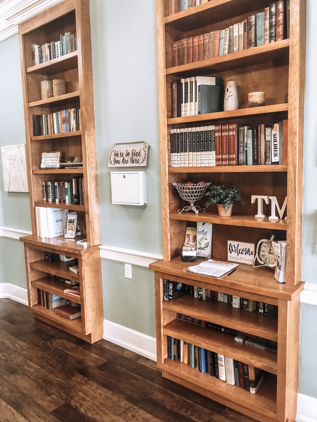 Beautifully styled wooden bookshelves filled with books and decorative items in a cozy living room.