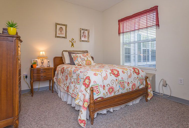 Cozy bedroom with floral bedding and natural light.