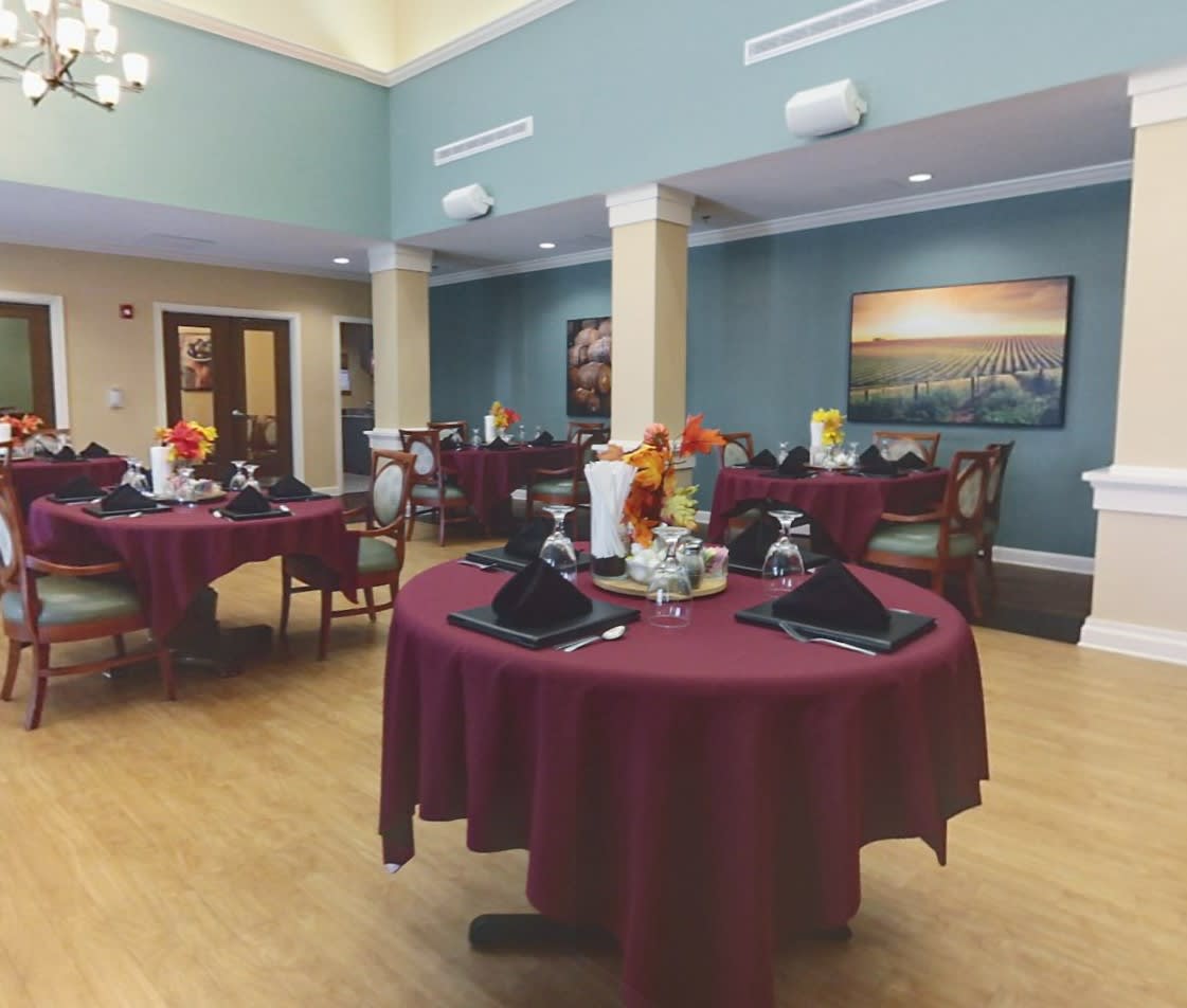 An elegant dining room with round tables set for guests.
