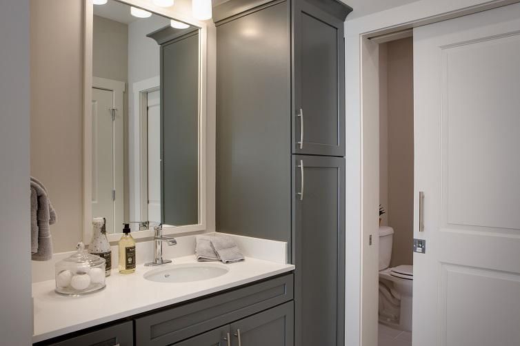 A modern bathroom with a sleek cabinet, mirror, and elegant lighting.