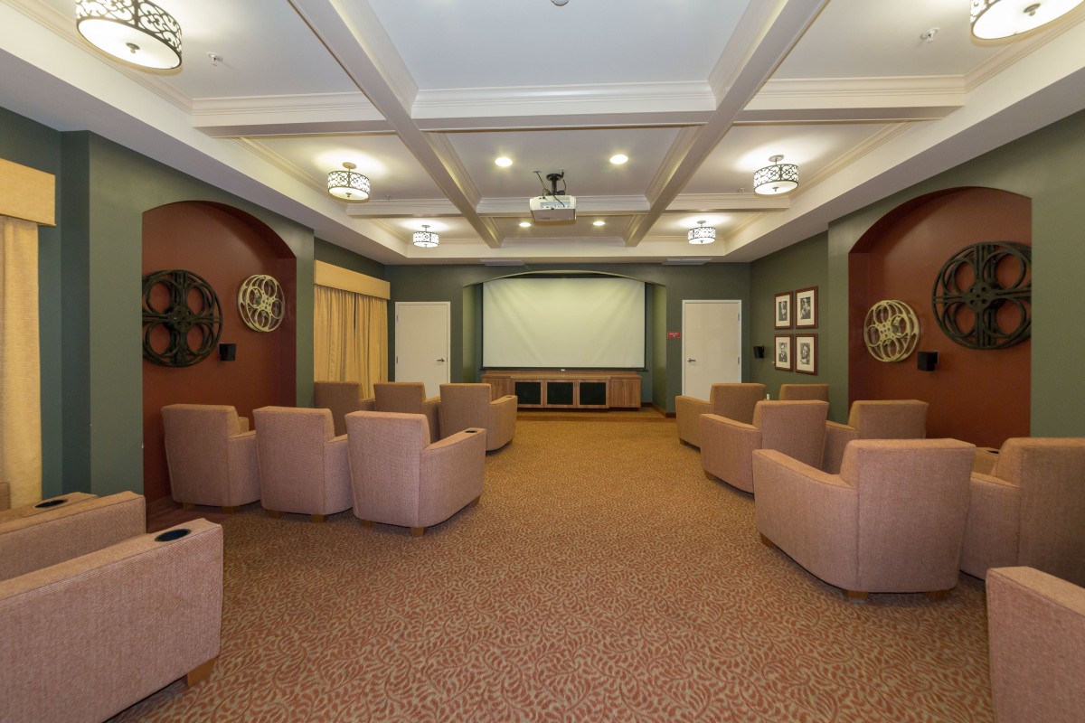A cozy home theater room with comfortable chairs and a large screen.