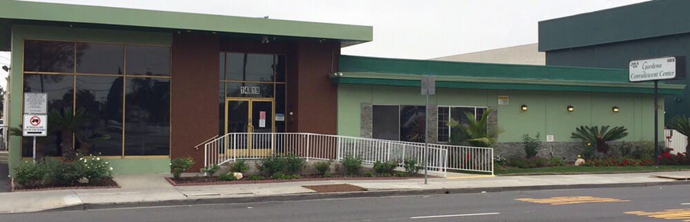 A modern commercial building with a green facade and large windows.