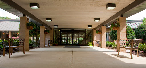 A welcoming entrance to a modern building, featuring a spacious lobby and decorative plants.